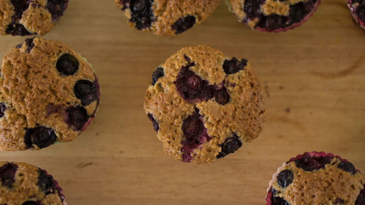 Delicious homemade blueberry muffins on a wooden table, perfect for breakfast or dessert.